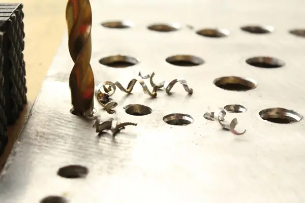 Close-up of cobalt drill bit tip cutting through metal