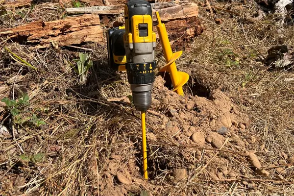 Assortment of heavy-duty earth auger drill bits on a construction site
